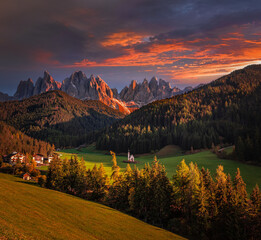 Val Di Funes, Dolomites, Italy - The beautiful St. Johann Church (Chiesetta di San Giovanni in Ranui) at South Tyrol with the Italian Dolomites and colorful golden sunset sky at background