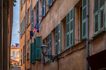 Traditional old houses on a narrow crooked street in the Old Town, Vieille Ville in Nice, French...