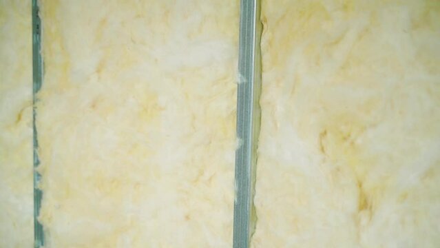 Glass wool between the metal U profile, close-up. Smooth camera movement