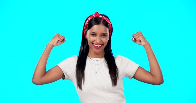Flexing, empowerment and woman showing arm muscle, strong and happy person isolated in a studio blue background. Bicep, strength and portrait of an excited female for body positivity