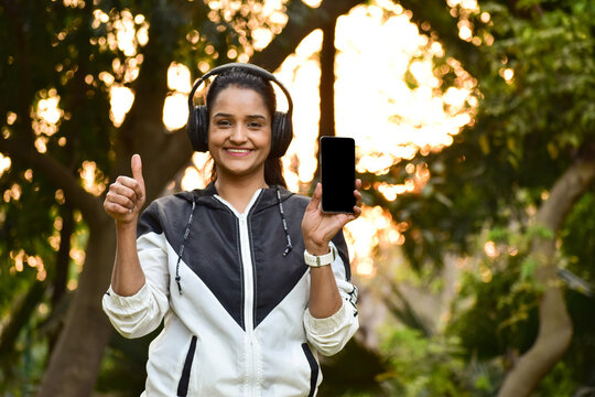 happy woman with headphones in park