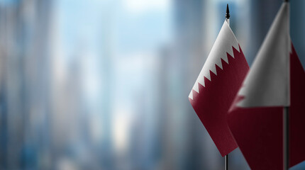 Small flags of the Qatar on an abstract blurry background