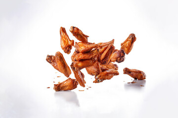 Fototapeta premium Tasty falling fried spicy chicken wings isolated on white background. Created with Generative AI Technology