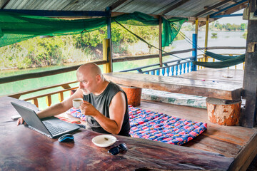 Digital Nomad working productively on his laptop,Don Det,4000 Islands,Laos.