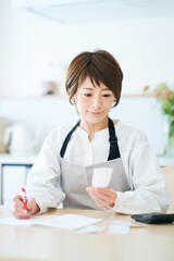 レシートを確認するエプロン姿の女性