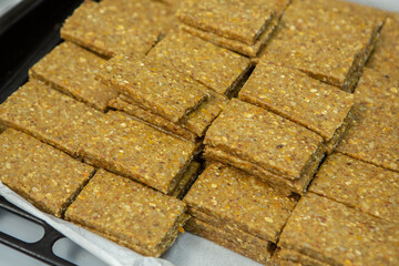 Assortment of cereal or protein bars that leave the assembly line at the factory. Healthy pre or post workout snacks with fruits, nuts and berries. 