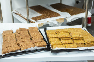 Assortment of cereal or protein bars that leave the assembly line at the factory. Healthy pre or post workout snacks with fruits, nuts and berries. 