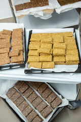 Assortment of cereal or protein bars that leave the assembly line at the factory. Healthy pre or post workout snacks with fruits, nuts and berries. 