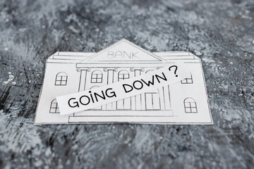 insolvency and banks closing down concept, bank made of paper with Going Down ? caption above it