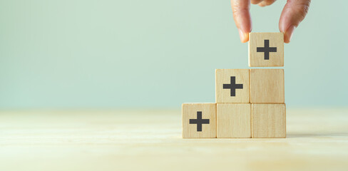 Positive things; added value, benefits, additional, personal development, growth mindset, positive thinking, opportunities, emerging market. Putting the cubes with plus sign to offer positive things.