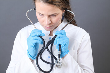 portrait of a young woman doctor with a stethoscope in sterile gloves close-up