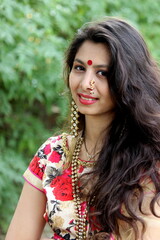 Naklejka premium Indian marathi woman with nose ring dressed up in traditional indian outfit looking at camera and giving beautiful expressions