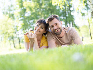 Couple laying at grass in field