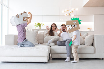 Children play cardboard dinosaur costume
