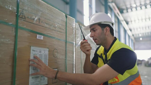 Professional caucasian elegant young engineer holding a radio communication talking with colleague to inspect the products in the factory
