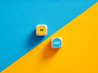 The words Do and Don't on wooden cube push buttons. Do's and Don'ts concept.
