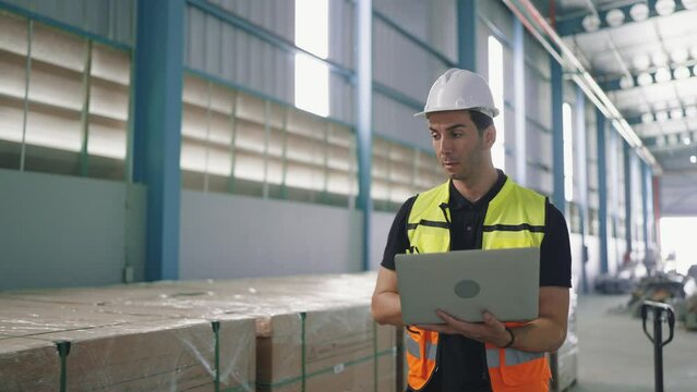 Professional young engineer man holding labtop for working recheck stock of product in the factory Industrial