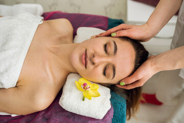 Obraz na płótnie Canvas female beautician doing facial massage her female client in a beauty clinic