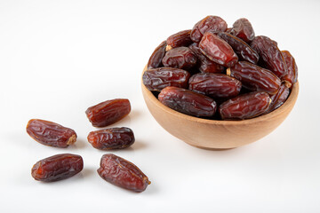 Date fruits in wooden bowl,on white background,top view