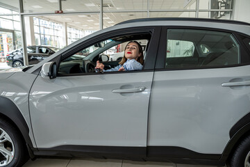 Fototapeta premium pretty smile young woman client inside at new modern auto and holding key, purcase concept