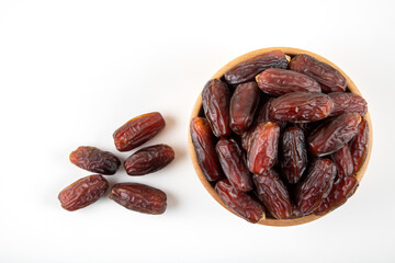 Date fruits in wooden bowl,on white background,top view