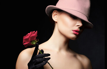 Fototapeta premium Beautiful young Woman In Hat and Gloves holding Flower