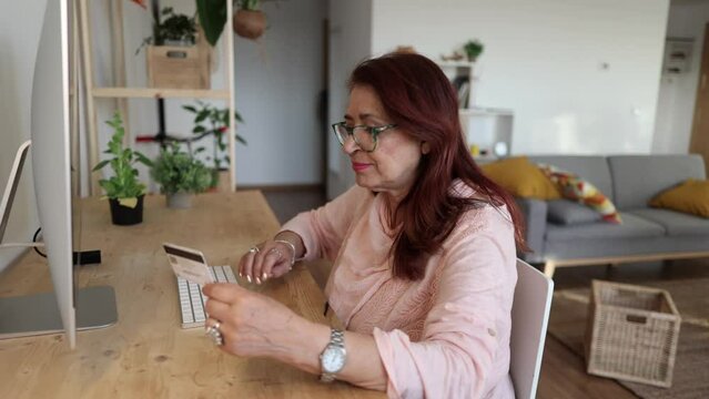 Chubby mature woman uses credit card to shop online at home