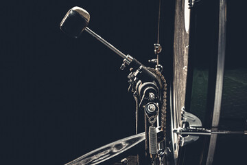 Bass drum with pedal, musical instrument on black background.