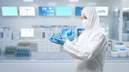 Worker wears medical protective suit or coverall suit with flask in laboratory