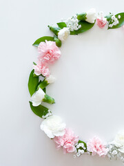 Round frame of pink and white carnations, leaves