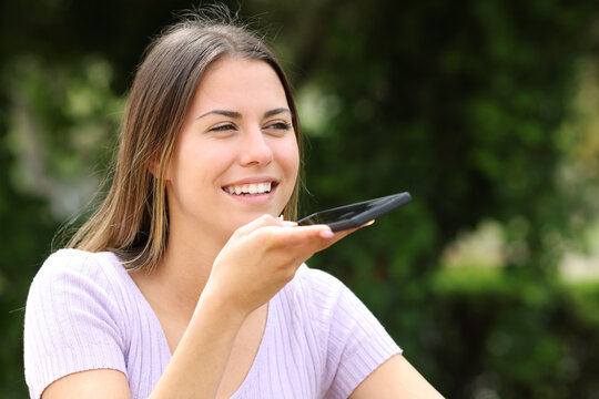 Teen dictating message on cell phone outside