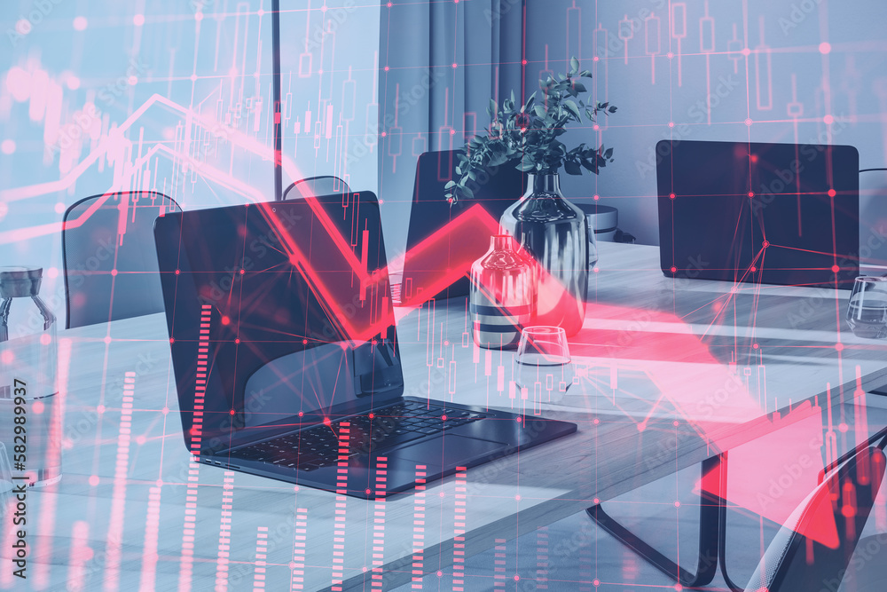 Poster close up of laptop on coworking office desktop with red candlestick arrow going down on blurry backg