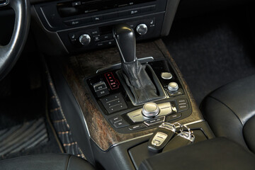 the central control panel of the car with the keys lying on it. climate control unit, automatic transmission with different modes