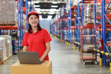 Portrait of warehouse workers young asian woman standing and using computer while looking at camera...