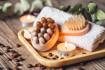 Spa composition with coffee massage scrub soap on a wooden surface.