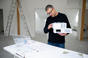 Design professional examining model home at construction site