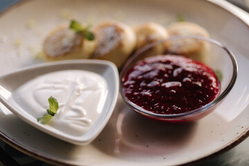 Freshly baked cottage cheese pancakes with strawberries jam and sour cream. Healthy food, mint leaf 