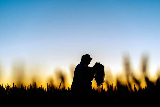 Silhouette romantic couple in field