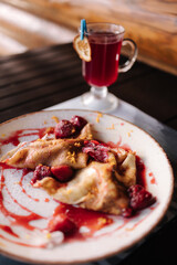 Homemade crepes, tasty thin pancakes with strawberry jam on wooden table