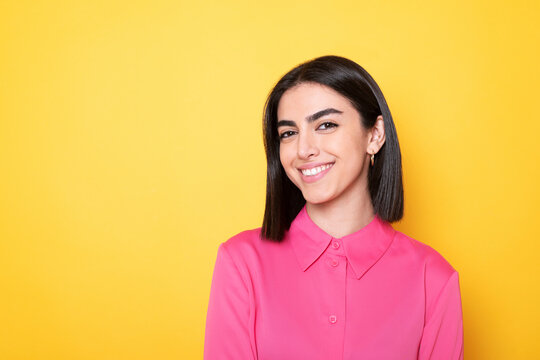 Happy young woman against yellow background