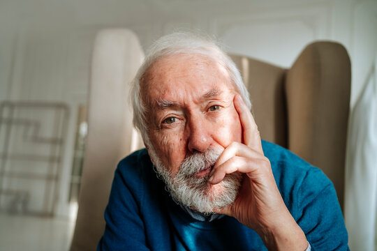 Thoughtful senior man with gray hair sitting at home