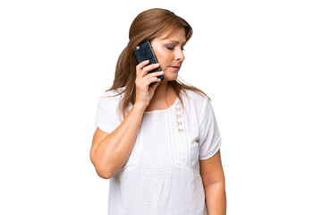 Middle-aged caucasian woman over isolated background keeping a conversation with the mobile phone with someone