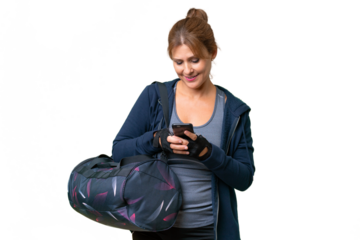 Middle-aged sport woman with sport bag over isolated background sending a message with the mobile