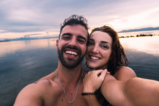 Happy couple taking selfie together at beach