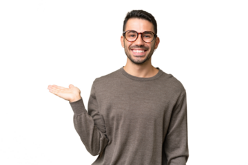 Young handsome caucasian man over isolated background holding copyspace imaginary on the palm to insert an ad