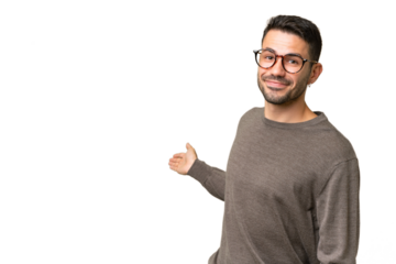 Young handsome caucasian man over isolated background extending hands to the side for inviting to come