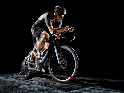 Determined athlete sitting on turbo dinner against black background
