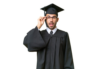 Young university graduate man over isolated background with glasses and surprised