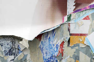Shabby poster paper background. Vintage billboard with torn ads as texture.
