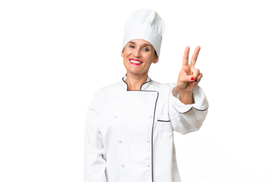 Middle-aged chef woman over isolated background smiling and showing victory sign